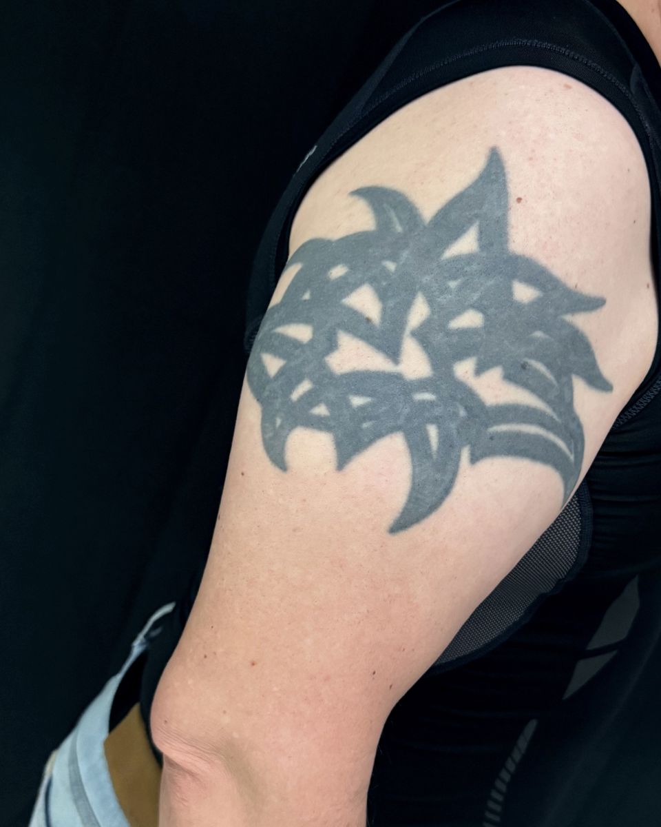 Vorher: altes schwarzes Tribal-Tattoo auf dem Oberarm