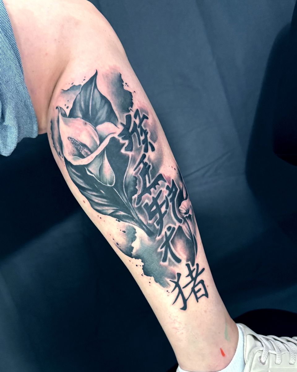Nachher: Schriftzeichen eingebunden in Blüte, Blatt und Rauch in Black and Grey auf der Wade